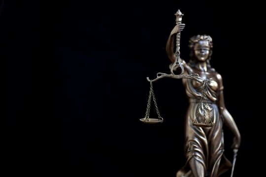 Lady Justice dark statue in law on black backdrop. Law and justice concept
