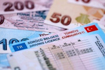 Turkiye driving permit concept. Driver license and turkish liras money bills close up