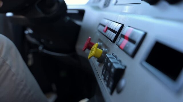  The driver hand turns on the tractor trailer air brake buttons on the truck dashboard. 