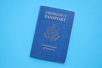 United States emergency passport book on light blue paper background close up. Travel document on blue surface