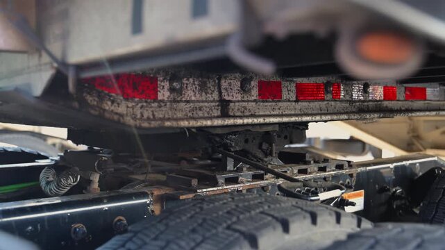 Trucker unhooking the trailer on the parking lot. Slow motion. bottom view