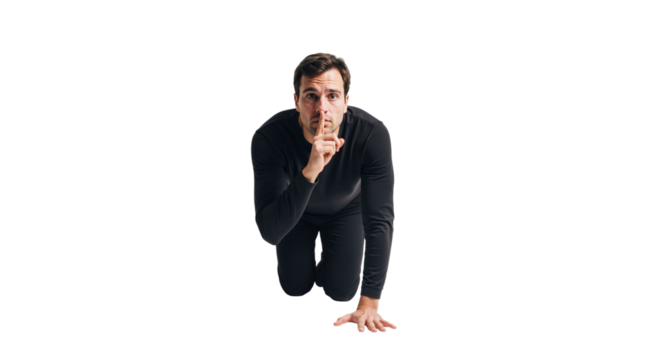 Man in black attire gesturing silence with index finger over mouth isolated