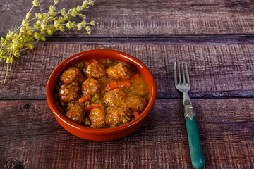 Close-up of a clay bowl with typical Spanish meatballs.