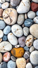 A close-up shows a diverse collection of smooth, colorful pebbles filling the frame