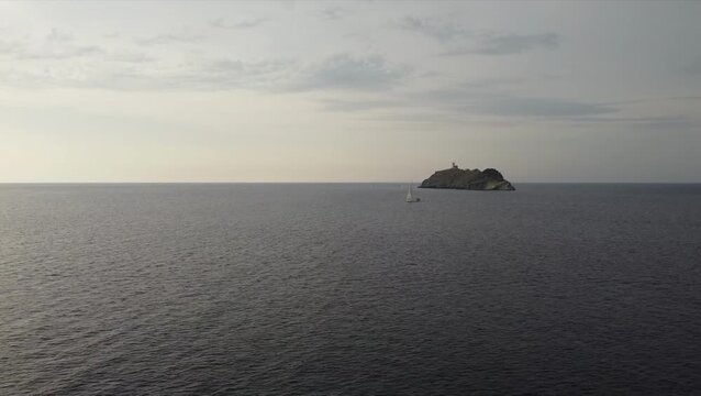 Aerial view of La Giraglia Island, Cap Corse, Corsica, France. Small rocky island with lighthouse and Genoese tower in the Ligurian sea
