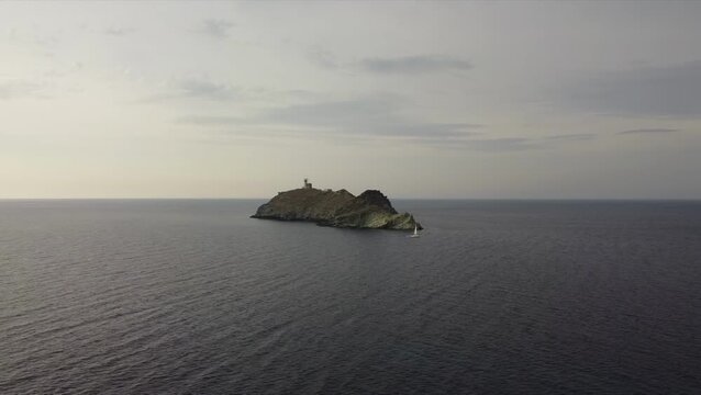 Aerial view of La Giraglia Island, Cap Corse, Corsica, France. Small rocky island with lighthouse and Genoese tower in the Ligurian sea