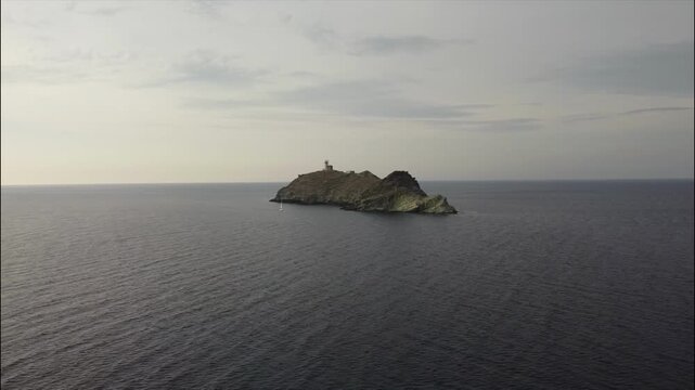 Aerial view of La Giraglia Island, Cap Corse, Corsica, France. Small rocky island with lighthouse and Genoese tower in the Ligurian sea