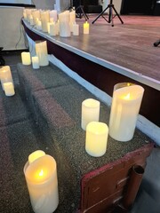 Burning candles on the stage where musical instruments are placed