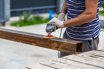 A man processes a metal pole. Selective focus.