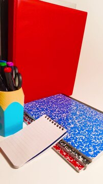 Dynamic back to school concept with vibrant notebooks and bold red folder showcasing education, organization, and colorful learning materials for students and teachers