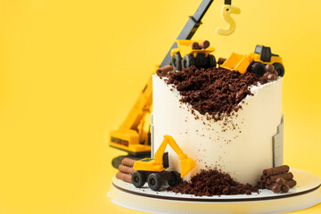 Birthday cake for five year old kid, decorated with construction vehicles. Heavy car themed homemade cake for toddler boy birthday celebration with toy excavators and crane on the yellow background.