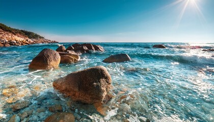 sunny coastal rocks clear shallow water and waves