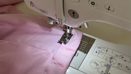 Close-up of Sewing Machine Presser Foot Stitching Pink Fabric