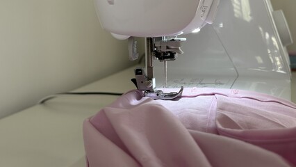 Close-up of Sewing Machine Presser Foot Stitching Pink Fabric