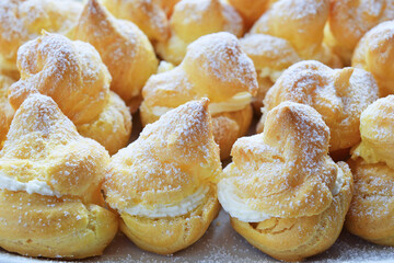 Close-up of tasty homemade sweet dessert with cream puffs on a plate.