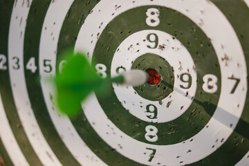 Close-up of dart striking the bullseye on target board