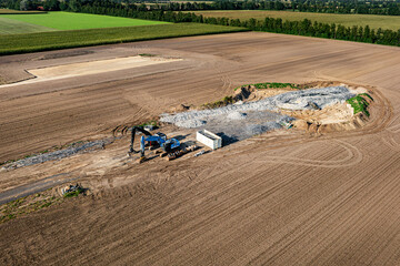 Repowering beim Windstrom - Schuttberg eines gesprengten Windrades, daneben ein Bauplatz für eine neue Windkraftanlage.