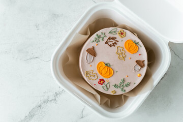 Autumn themed and Halloween festive bento cake in a gift box on the white marble background