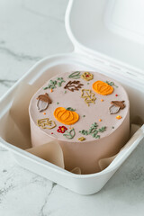 Autumn themed and Halloween festive bento cake in a gift box on the white marble background