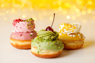 Hanukkah holiday card with sweet doughnuts sufganiyot (traditional donuts) and bokeh lights. Selective focus. Yellow banner