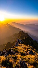Naklejka premium A mountain range at sunset is captured with a bright sun and haze across the landscape