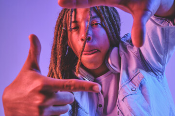 Person framing with hands in neon light