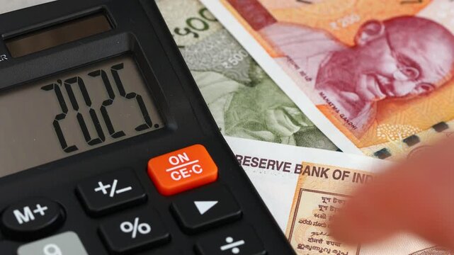 India. Fiscal year 2026. Business and economics. Symbol of the Indian rupee. Counting money. Year 2025 on a calculator, changing to 2026. Financial background. close up