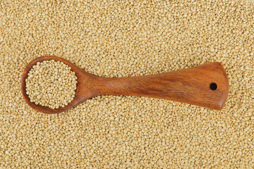 white quinoa seeds in wooden spoon as a background. Top view. Flat lay