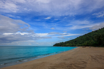 Beach with a blue ocean and a mountain in the background