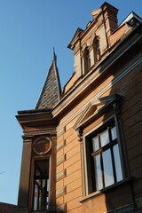 Old house in historical center of Brasov city in Romania with steep metal roof and pediment above window