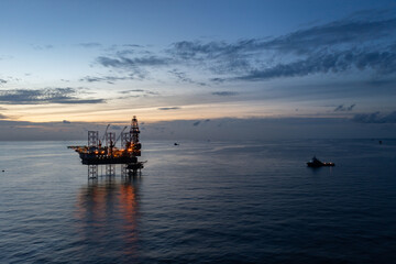 Aerial view of offshore jack up rig and offshore platform during sunset for oil and gas exploration...