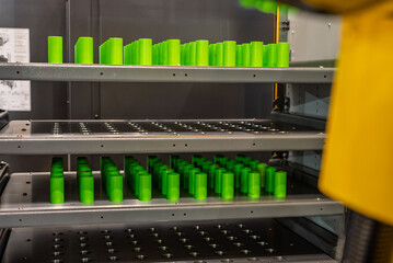 Drawer with CNC details. The robot arm places part and shafts on a pallet. Production automation. Robotic inspection arm analyzing machined components for quality control