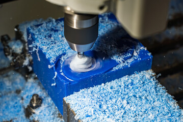 Metalworking CNC lathe milling machine with coolant. Milling  a piece of plastic. Industrial metalworking cutting process on cnc machine. Milling tool works on a CNC milling machine