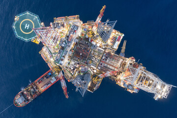 Aerial view of offshore jack up rig and offshore platform during sunset for oil and gas exploration...