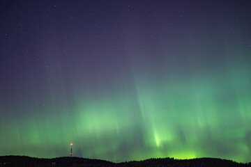 Strong aurora over Nordic city night sky