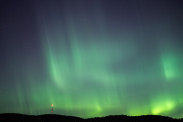 Strong aurora over Nordic city night sky