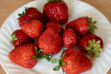 Fresh Red Strawberries on White Plate, Juicy Berries for Snack or Dessert. Top view, selective focus
