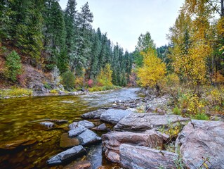  LArge rocks by a mountain stream in fall.