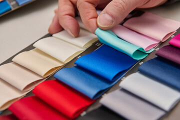 Hand selecting colorful fabric swatches, product photo, studio shot, clean studio background,...