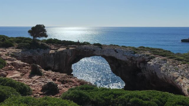 Aerial view of Cala Varques suspended rock arch above the mediterranean sea in mallorca