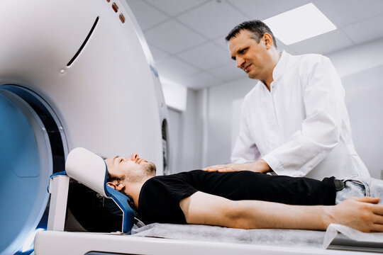 Medical professional assisting patient on CT scanner, demonstrating advanced imaging technology in a clinical environment with modern design and healthcare focus