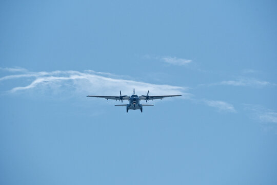 Two-engine airplane in the blue sky. Turboprop transport aircraft