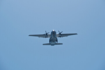 Two-engine airplane in the blue sky. Turboprop transport aircraft