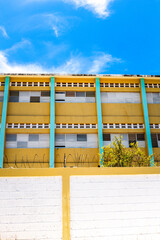 Pedernales, Dominican Republic, 8 august 2025. View of the facade of a typical Dominican school, paintend bright yellow against a blue sky.