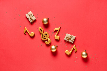 Composition with music notes, Christmas decorations and gifts on red background