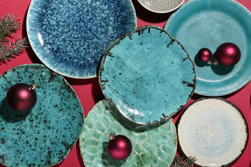 Beautiful table setting with Christmas balls and fir branches on color background