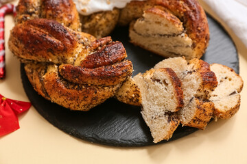 Slate board with tasty Christmas pastry wreath on color background, closeup