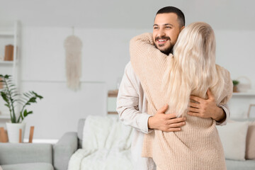 Young man hugging his mother at home