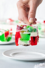 A hand serving a homemade gelatin dessert square onto a plate.