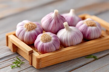 Macro Close Up Of Fresh Garlic Cloves With Purple Streaks Arranged In A Wooden Tray On A Light Gray Rustic Wooden Surface With Soft Natural Lighting